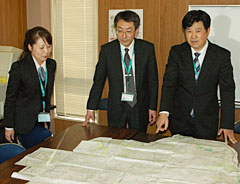 七ヶ浜支店管内の被害状況とＪＡ共済加入者を確認するために急遽作成した白地図を前に（左から）佐藤さん、笹支店長、鈴木さん