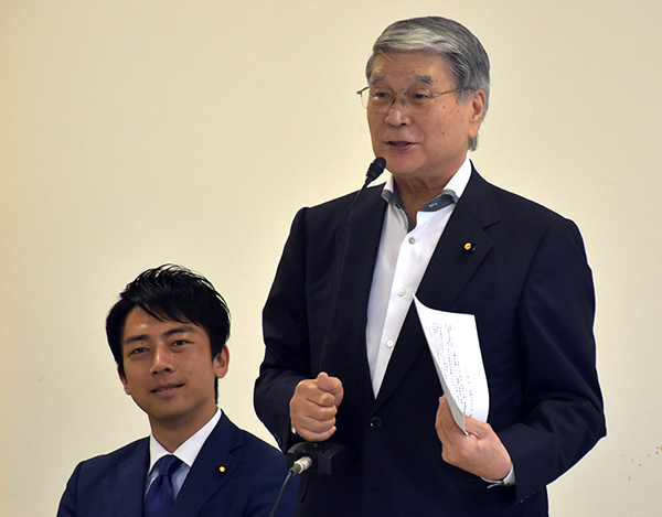 小泉前部会長（左）から渡された引き継ぎ書を手にあいさつする野村新農林部会長