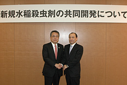 共同開発に向けて握手する神出専務（左）と田中社長