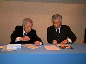 署名する澄田ユニセフ会長（左）と小倉日本生協連会長（右）