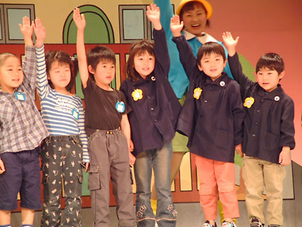 歌と踊りの舞台に上がって横断歩道の渡り方を学ぶ園児たち＝15日、東京・一ツ橋の日本教育会館