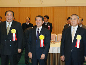 「16年間、お疲れさまでした」の羽隅前副理事長（中央）を囲む松木理事長（右）と青木新副理事長（左）