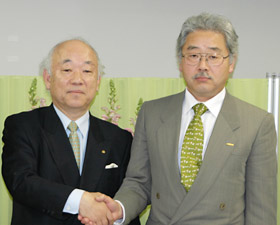 握手する内山社長（左）と山岸会長