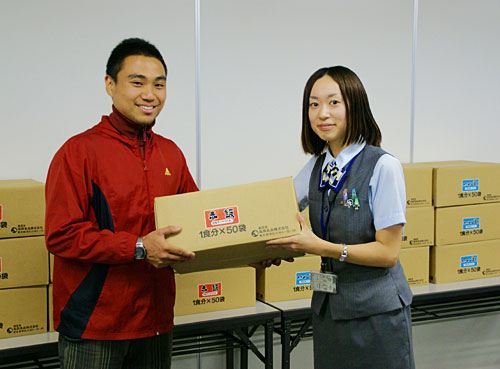 セカンドハーベスト・ジャパンの黒澤氏（左）に食料を寄贈するＪＡ共済連職員
