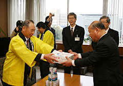 ＪＡ全農長野県本部の大槻憲雄副会長（写真・左）から腰原愛正長野県副知事へリンゴジュースを贈呈（３月10日＝長野県庁）