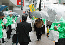 雨の中リーフレットを配布するＪＡ職員（秋葉原駅前） 