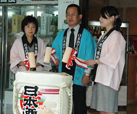正午を合図に鏡開きをする日本酒造組合中央会山本純一常務理事(中央)