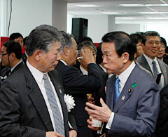 竣工披露式典で麻生首相（右）と談笑する茂木会長