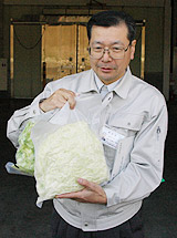カット野菜のパックを手にする小井土センター長