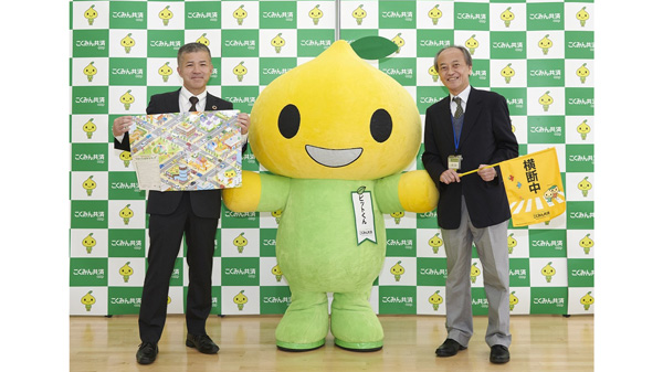 横断旗寄贈に臨んだ鷺の杜小学校の武智校長（右）とくみん共済 coopの仲田昌純常務理事