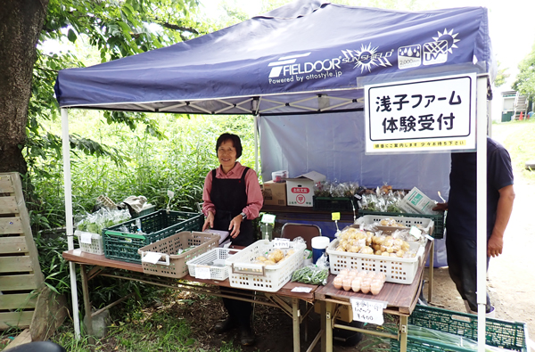 有機野菜が並ぶ浅子ファームの直売コーナー。店に立つのは幹夫さんの妻、浅子紀子さん