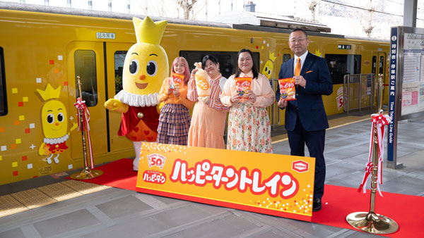 出発式の最後にテープカットを行った亀田製菓の髙木政紀社長（右）、ハッピーターンのキャラクター・ターン王子、ぼる塾の3人