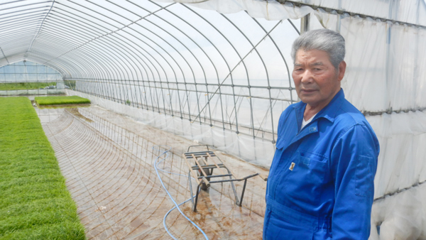 育苗ハウスの前の和田さん