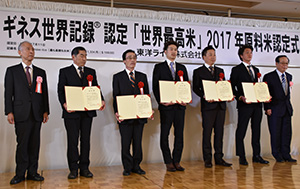 新たに認定された「世界最高米」原料玄米生産者と雑賀社長（左）