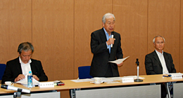 （左から）鈴木英夫常務理事、あいさつする長岡武理事長、山中氏