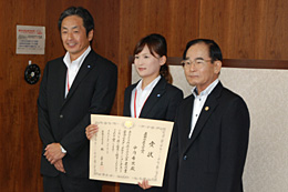 表彰式を受けたタカキタの中内さん（中央）と松本社長。右は加治屋副大臣