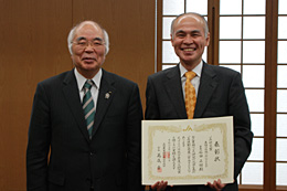 表彰状を持つ石田教授（右）と萬歳会長