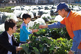 利用者に野菜作りをアドバイスする菜園アドバイザー（右）