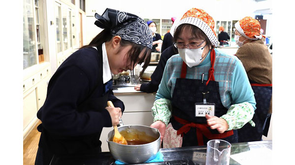 作り方を説明する女性部員（右）