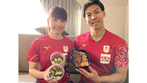 「おにぎり弁当」と「どんぶり弁当」を手に笑顔のカーリングミックスダブルス日本代表（提供：日本カーリング協会（JCA））