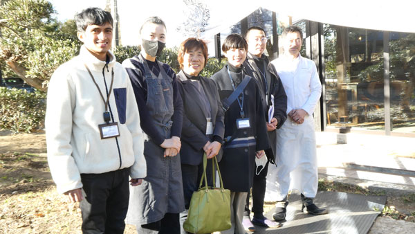 ラーメン店とカフェに再生した古民家の前で野老会長（左から3人目）と社員