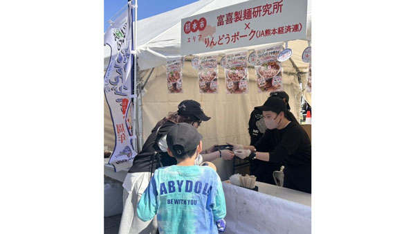 「シン熊本ラーメン『りんどうポーク中華そば』」を受け取る来場者