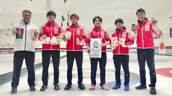 「ニッポンの食」を手に笑顔の カーリング男子日本代表（写真提供：JCA）