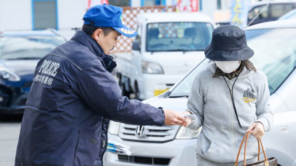 用者に詐欺被害防止を呼びかける警察署職員