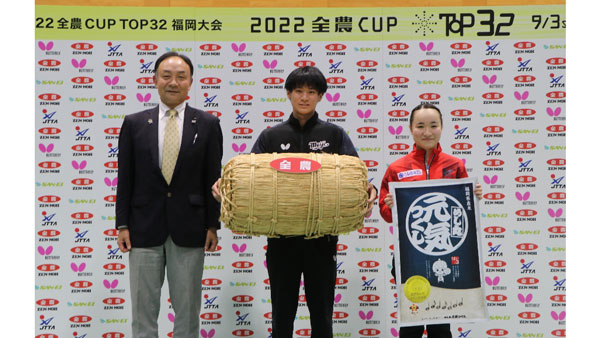 Male champion Togami (center) and female champion Ito (left) receive a bag of rice.