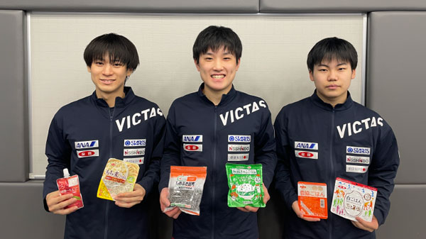 「ニッポンの食」を手にする戸上隼輔選手（左）、張本智和選手（中央）、松島輝空選手