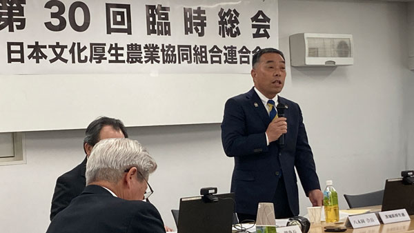 臨時総会であいさつする八木岡努会長