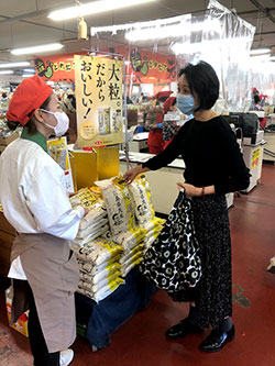 「贅沢あきろまん」発売当日、店頭で説明を受ける買い物客（広島市安佐南区で）