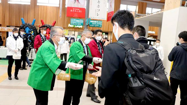 秋田駅の利用者におにぎりを配るＪＡ関係者ら