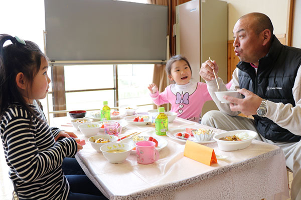 ひまわり保育園の園児と話をしながら昼食を楽しむ青年部員