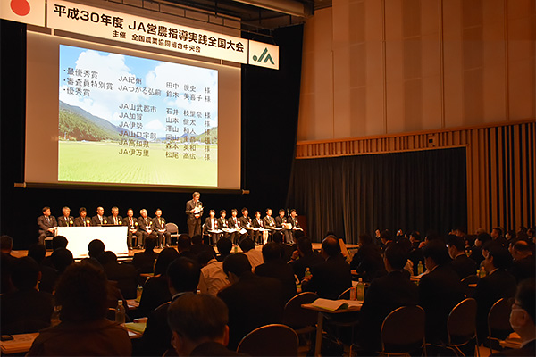 檀上に勢揃いした事例発表者　（所得向上・生産拡大へ意思統一 営農指導で全国大会）