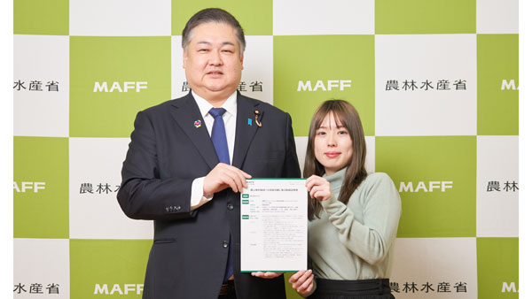 13日に農水省で行われた表彰式。農林水産大臣政務官の山本啓介氏（左）とバカン広報の原田真希氏