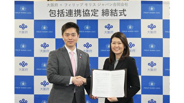 3月26日の協定締結式に臨んだ大阪府の吉村知事（左）とフィリップ モリス ジャパンのシェリー・ゴー社長