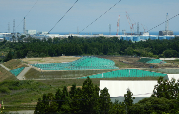 中間貯蔵施設と東電福島第一原発（後方右側が事故を起こした原発群）