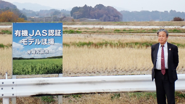 学校給食向けに有機米を作る有機ＪＡＳ認証ほ場の前に立つＪＡ常陸の秋山豊組合長（茨城県常陸大宮市）