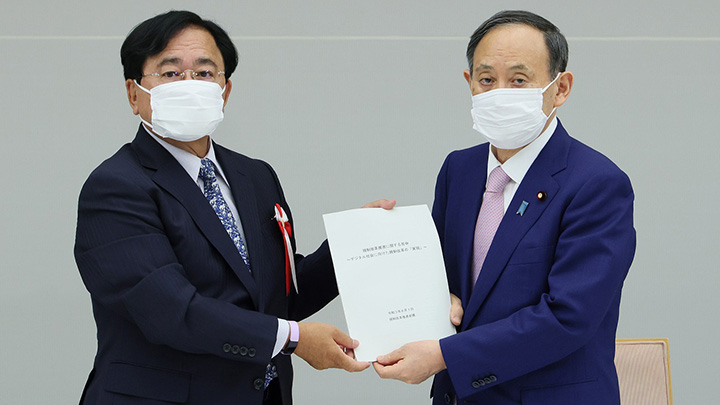 小林議長（左）から答申を受け取る菅総理