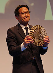 パビリオンプライズ授賞式でトロフィーを掲げる日本代表の加藤辰也氏