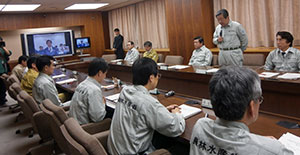 被害状況の把握と食料支援に全力を、と指示を出す森山農相。九州農政局もテレビ会議で参加(左画面）。4月17日霞ヶ関の農水省。