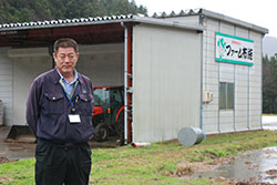 集落の中心部にある事務所の前で。松崎寿昌さんはＪＡしまね島根おおち地区本部大和支店の営農生活課長