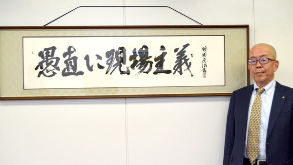 協友アグリの安藤敏社長。本社には「愚直に現場主義」の書が掲げられている。