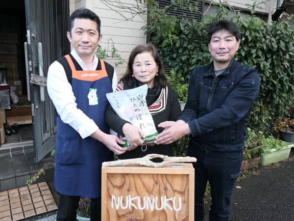 子ども食堂「ぬくぬくの家」井山さん（中央）を囲んで、米を手渡す生産者の青木さん（右）とパルシステム東京世田谷センターの増田さん