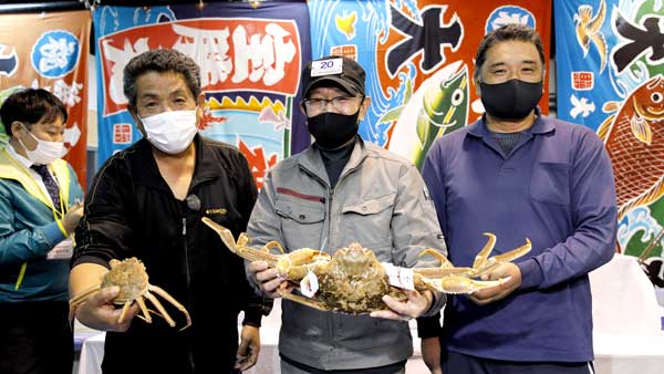 最高額で落札された加能ガニの最高級ブランド「輝」と雌のズワイガニ（香箱ガニ）の最高級ブランド「輝姫」を手にする関係者