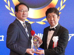 表彰式でオリコンの小池社長（右）からトロフィーを受け取ったパルシステムの渋澤専務理事