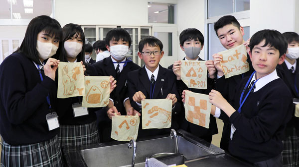 染め上がったハンカチを掲げる生徒（2024年度）