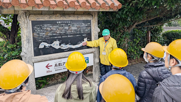 役職員19人が沖縄戦跡を視アブチラガマの説明を聞く参加者