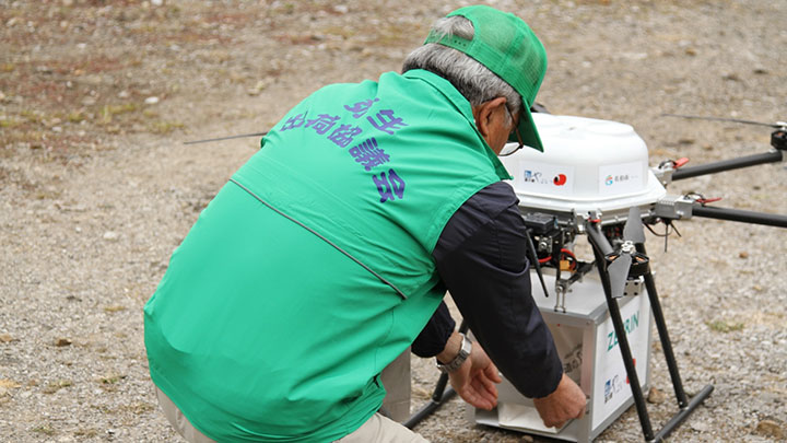 ドローンに農作物を積み込む生産者